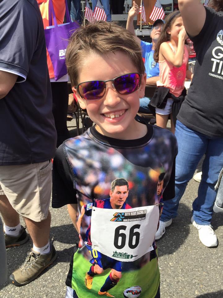 Young Parker in sunglasses at a local 5K, wearing bib 66